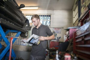 Mechanic reading manual in garage